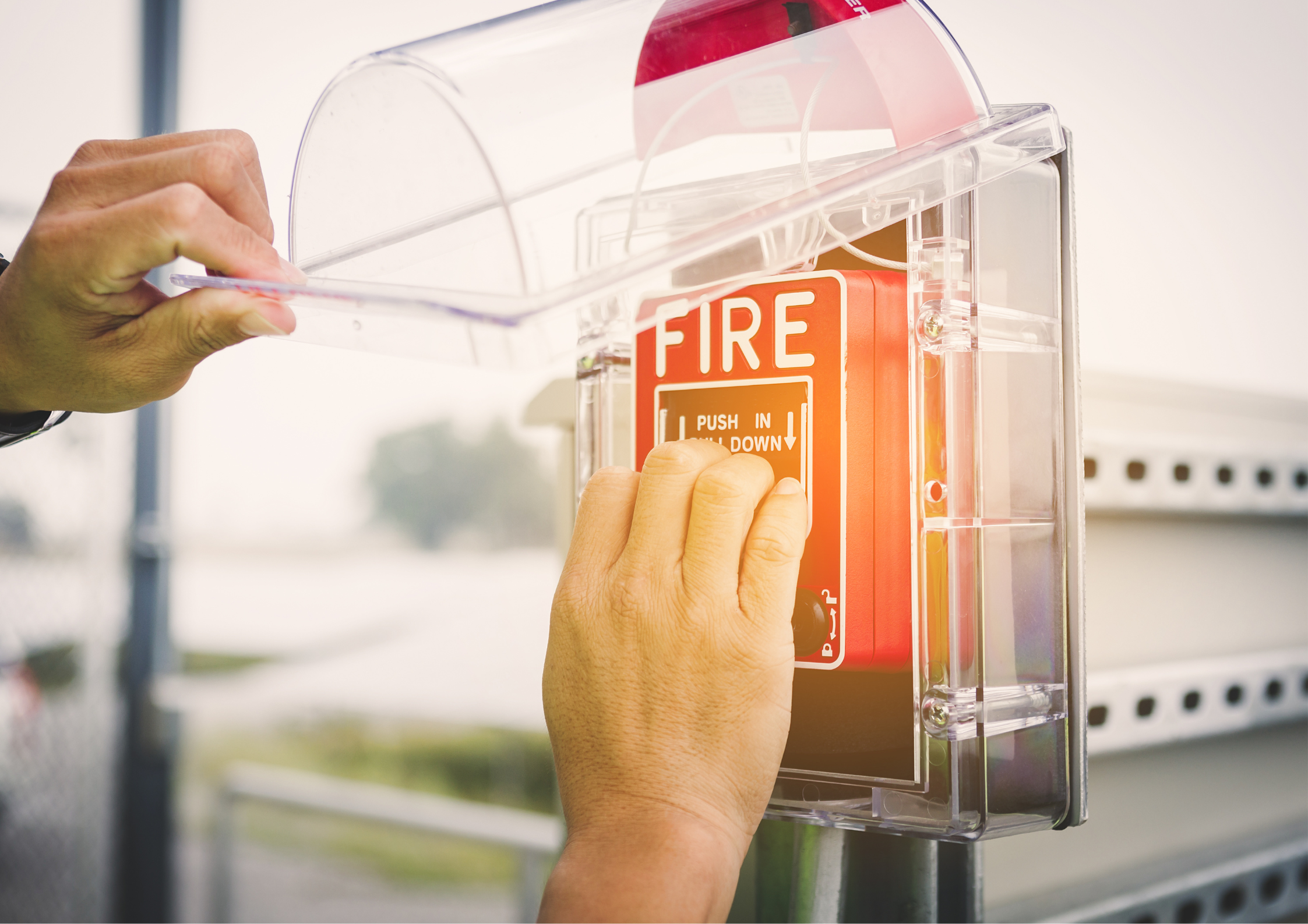 Person pulling a fire alarm handle.